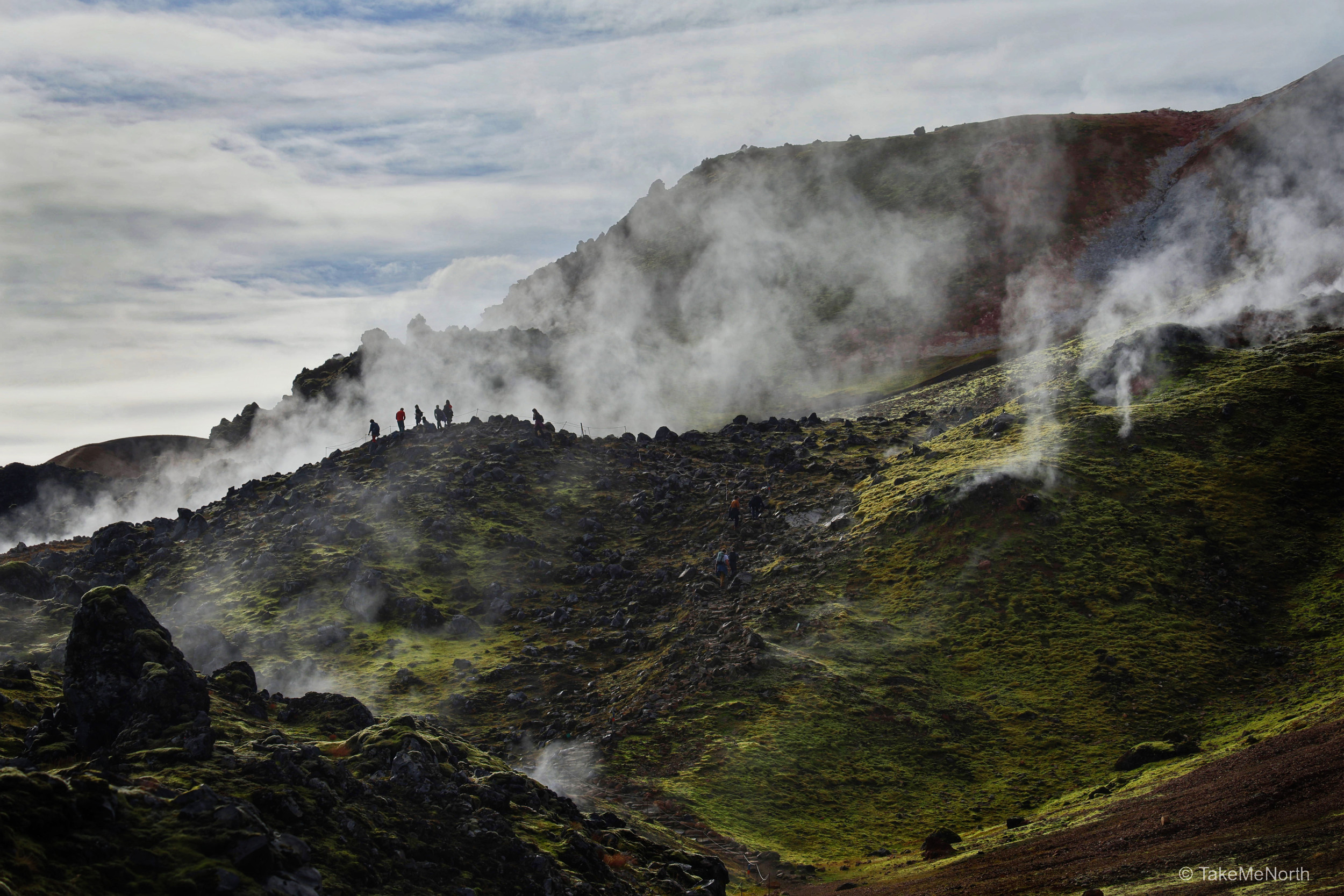 Steam and sulfur curl from  vents in the earth